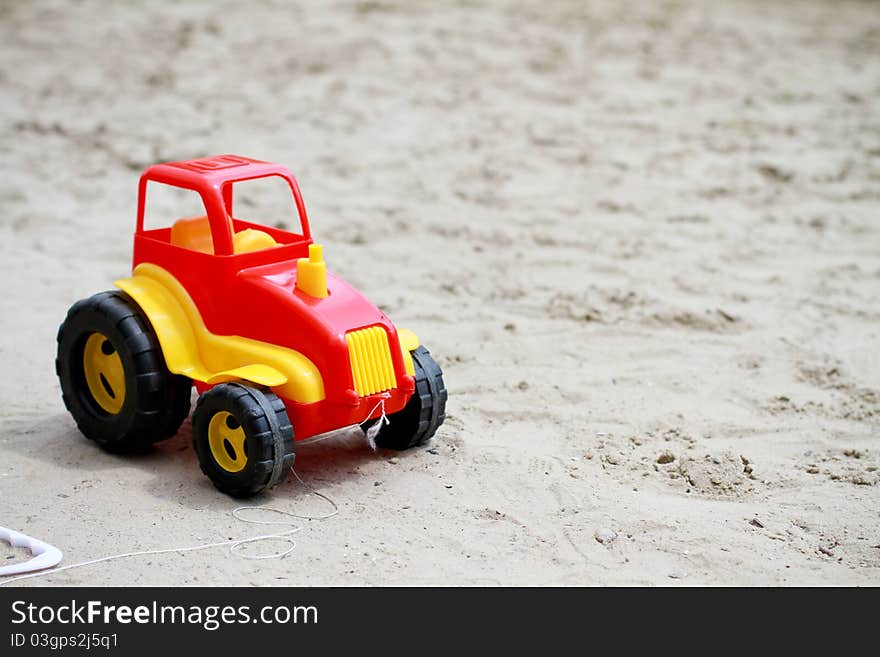 Little red toy car in sandbox