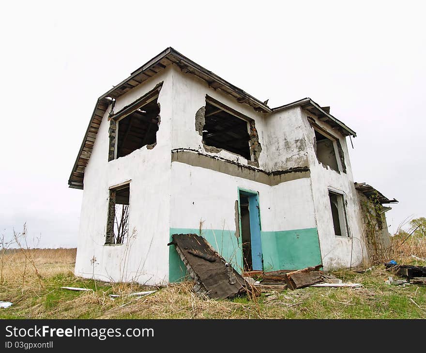 Crumbling abandoned house standing alone in the field