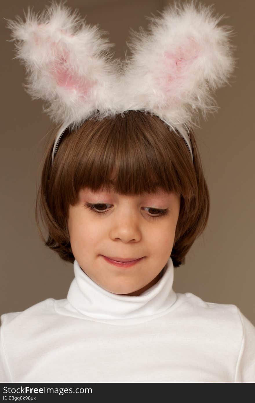 Studio portrait of smiling cute little girl wearing bunny ears on brown background. Studio portrait of smiling cute little girl wearing bunny ears on brown background