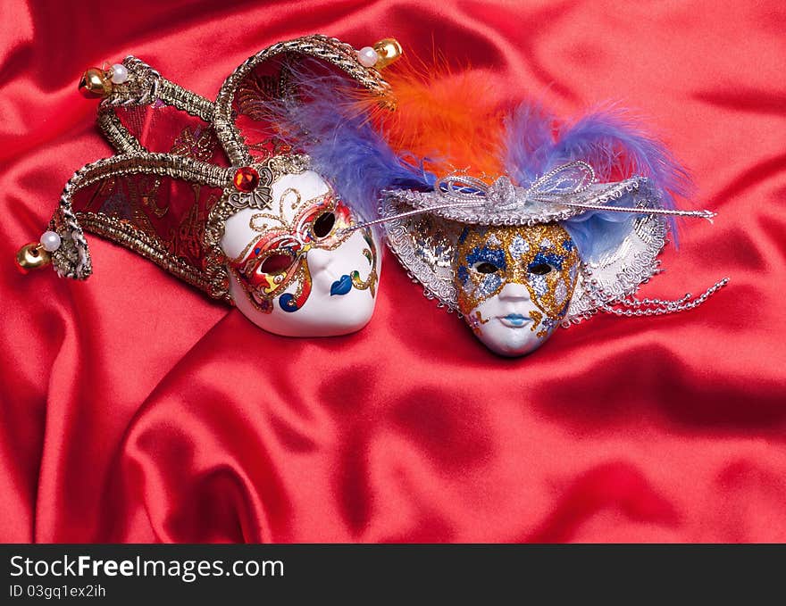 Two venetian mask on a red silk