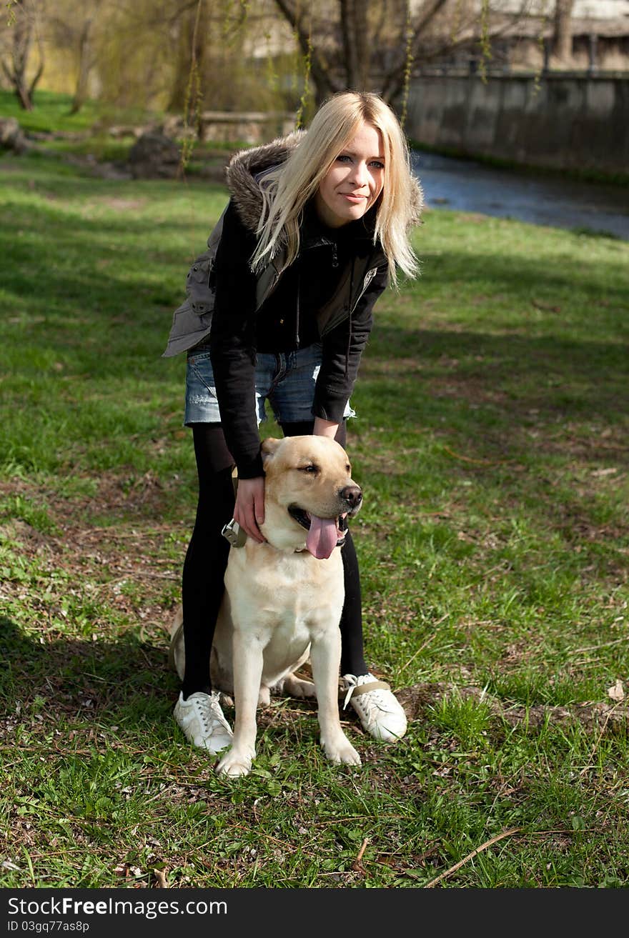 Outdoor shot of beautiful cheerful woman with dog in the park. Outdoor shot of beautiful cheerful woman with dog in the park