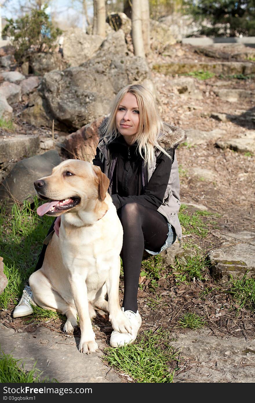 Outdoor shot of beautiful cheerful woman with dog in the park. Outdoor shot of beautiful cheerful woman with dog in the park