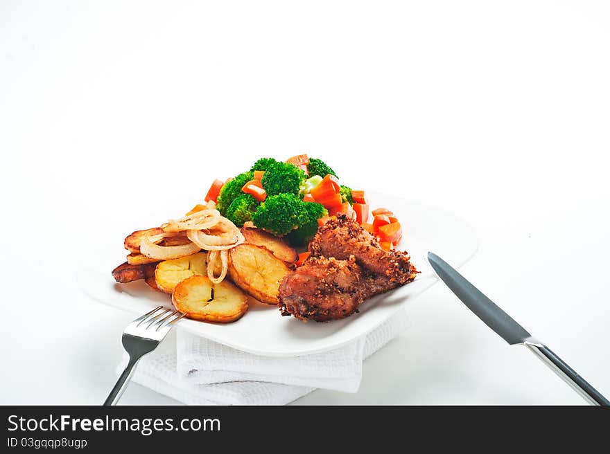 Fried potatoes broccoli carrots and roasted chicken on white background. Fried potatoes broccoli carrots and roasted chicken on white background