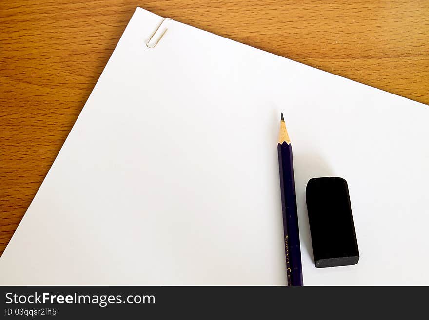 White paper with pencil and rubber on table