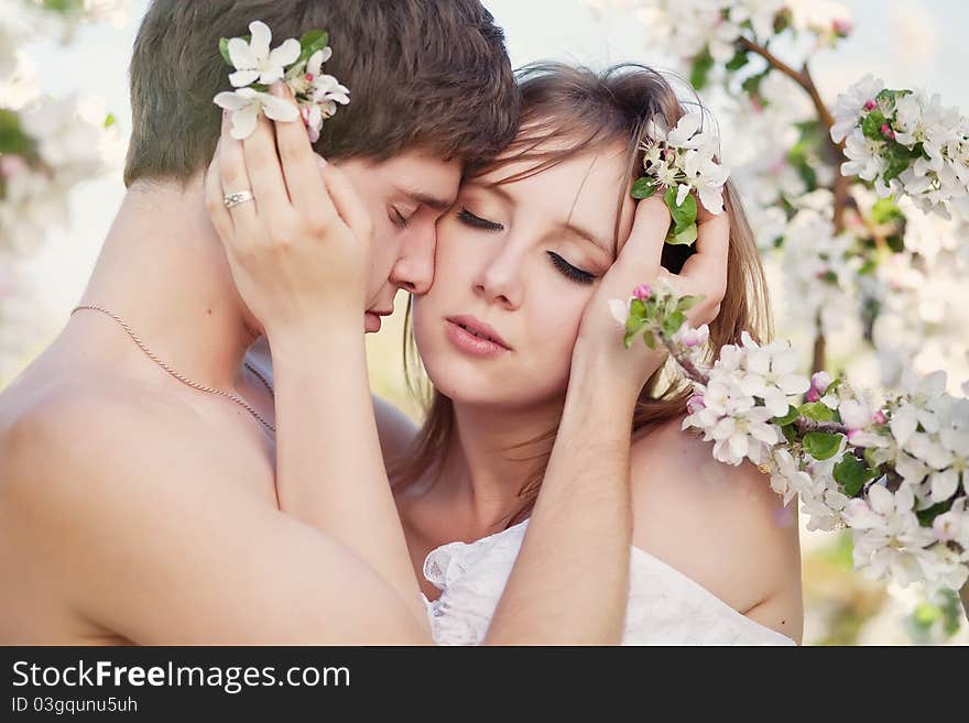 Beautiful Young Couple Kissing In The Flowering Ga