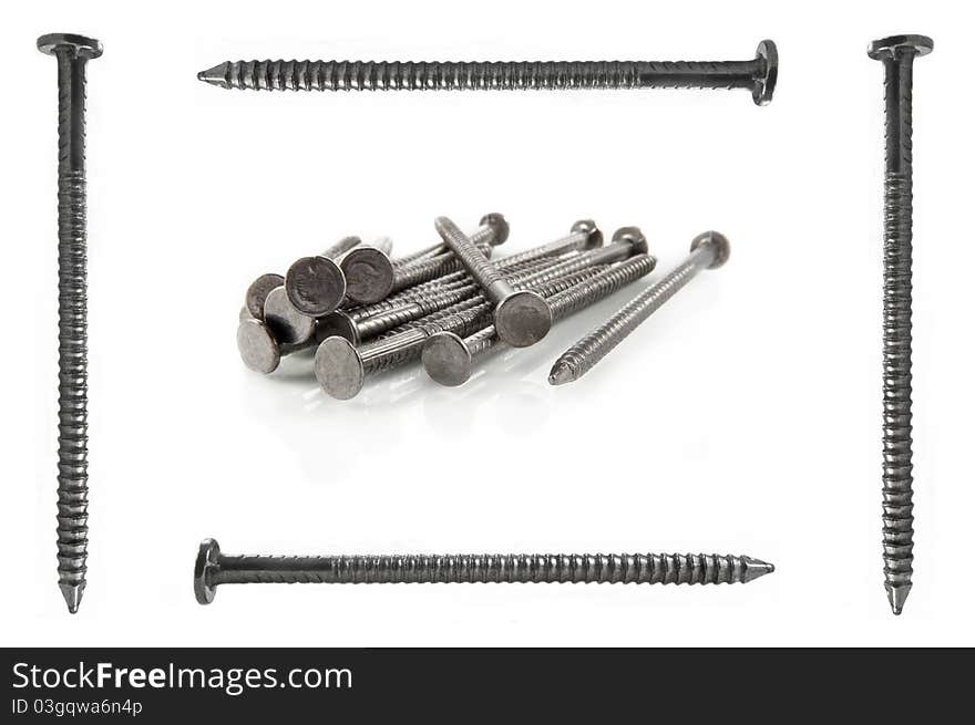 Four steel nails arranged around the border of the image with small pile of nails in the centre. White background. Four steel nails arranged around the border of the image with small pile of nails in the centre. White background