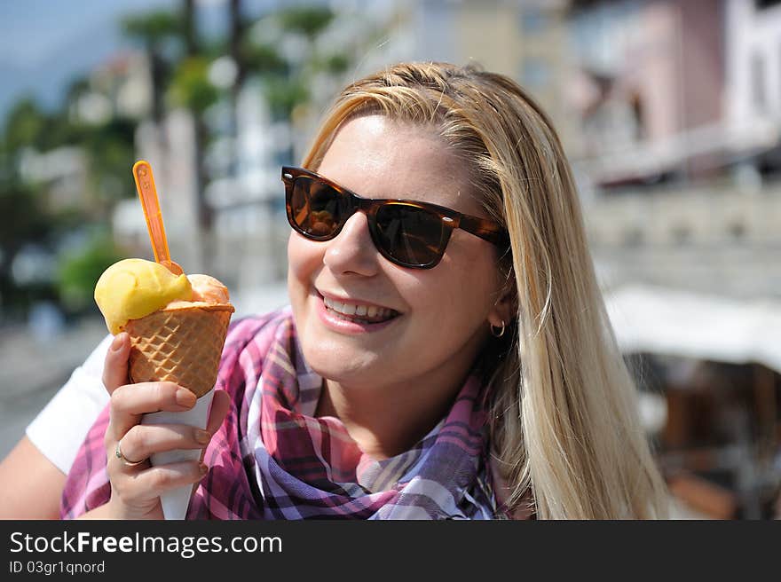 Pretty summer girl eating ice cream outdoors