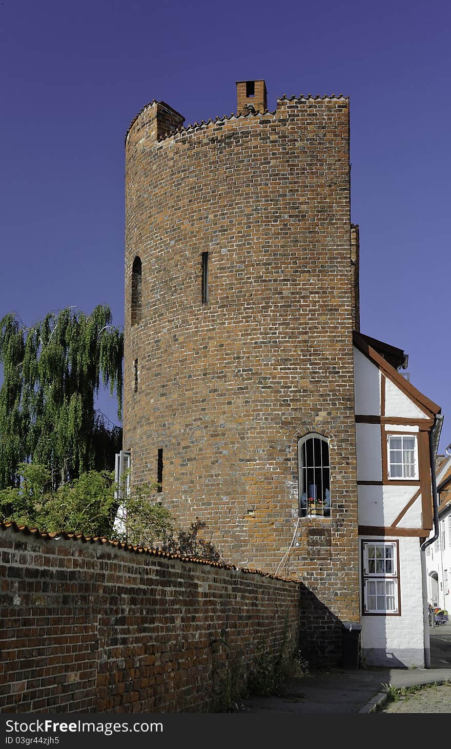 An interesting building in the ancient city of Luebeck in the northern part of Germany. The structure is half house and half tower. The tower was part of the old city walls in former times. An interesting building in the ancient city of Luebeck in the northern part of Germany. The structure is half house and half tower. The tower was part of the old city walls in former times.