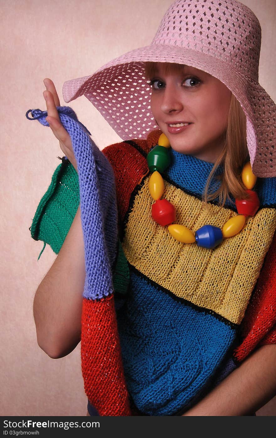 Funny Girl in a big hat and a multicolored knitted cape