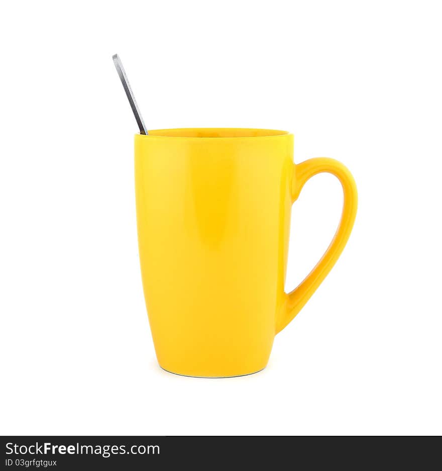 Empty yellow cup and spoon on a white background