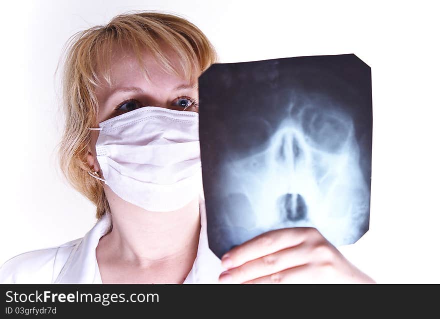 Serious female doctor looking at a x-ray against white background