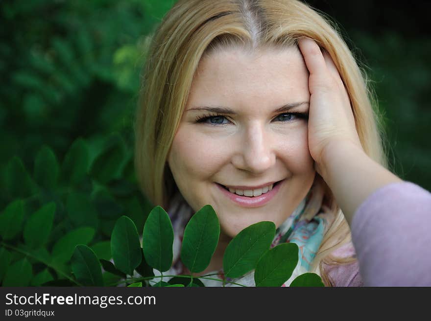 Pretty casual woman outdoors in green park smiling