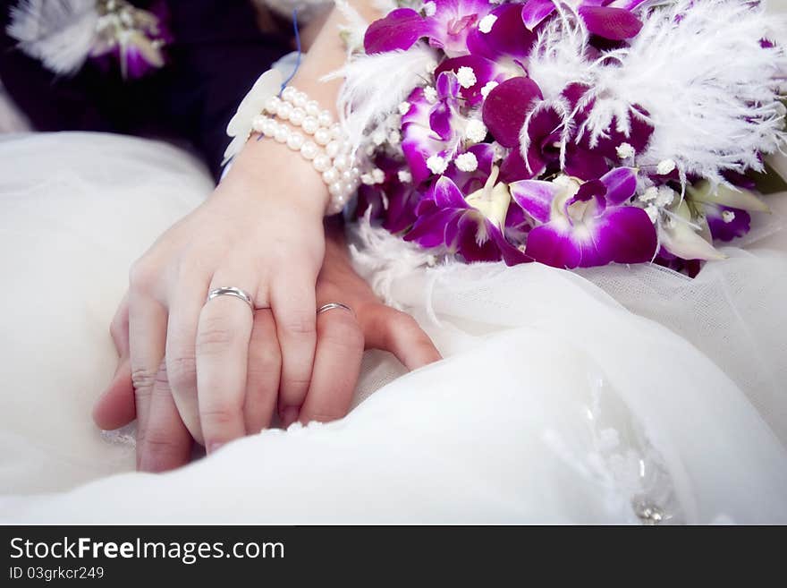 Hands and rings on wedding bouquet. Hands and rings on wedding bouquet