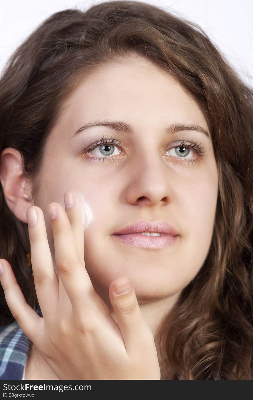 Caucasian young woman applying moisture