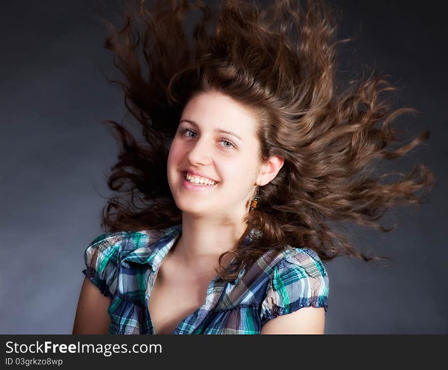 Young brunette woman with long flying hair, studio shot