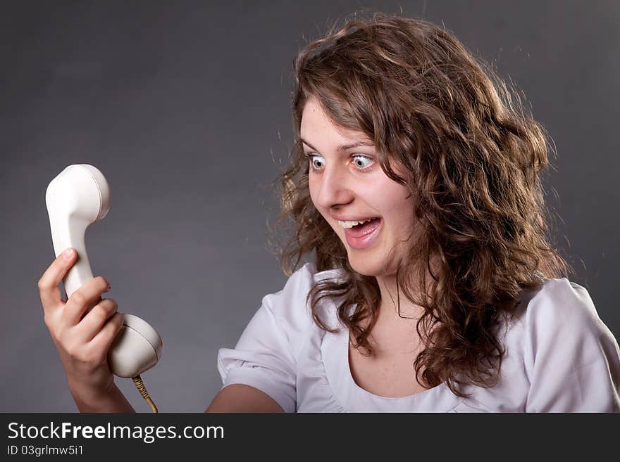 Woman talking on old phone with hair in the air. Woman talking on old phone with hair in the air