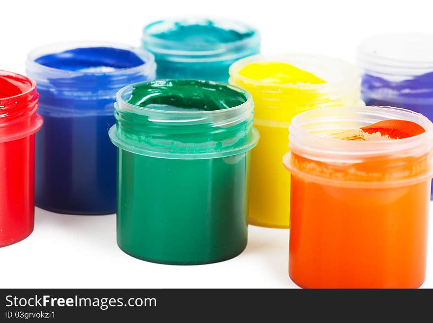 Closeup view red, green, yellow and blue cans with gouache