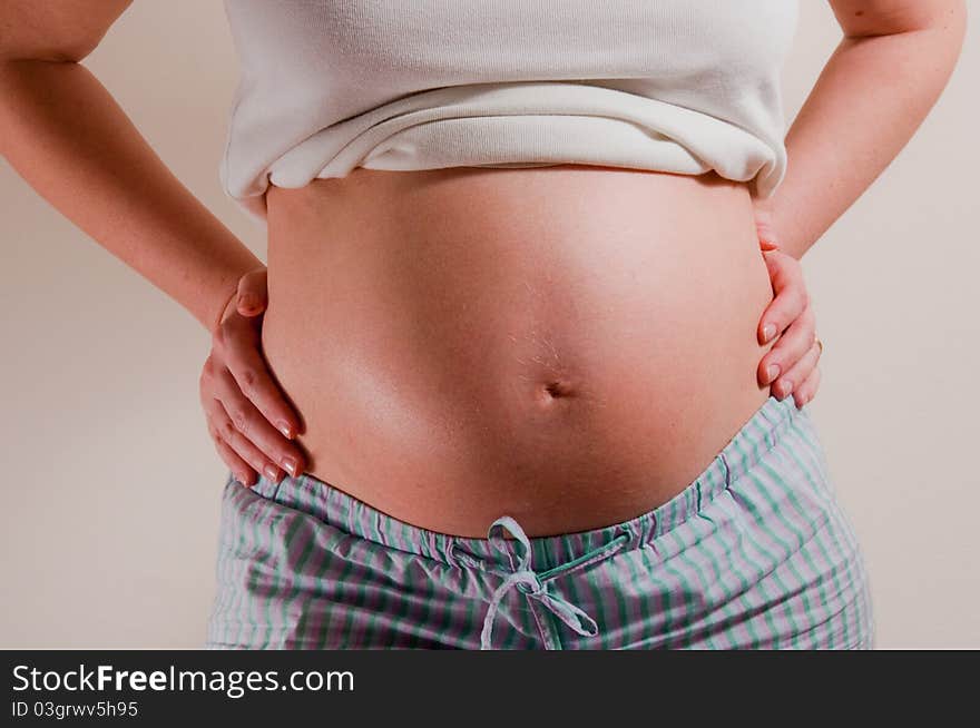 A pregnant girl on uniform background