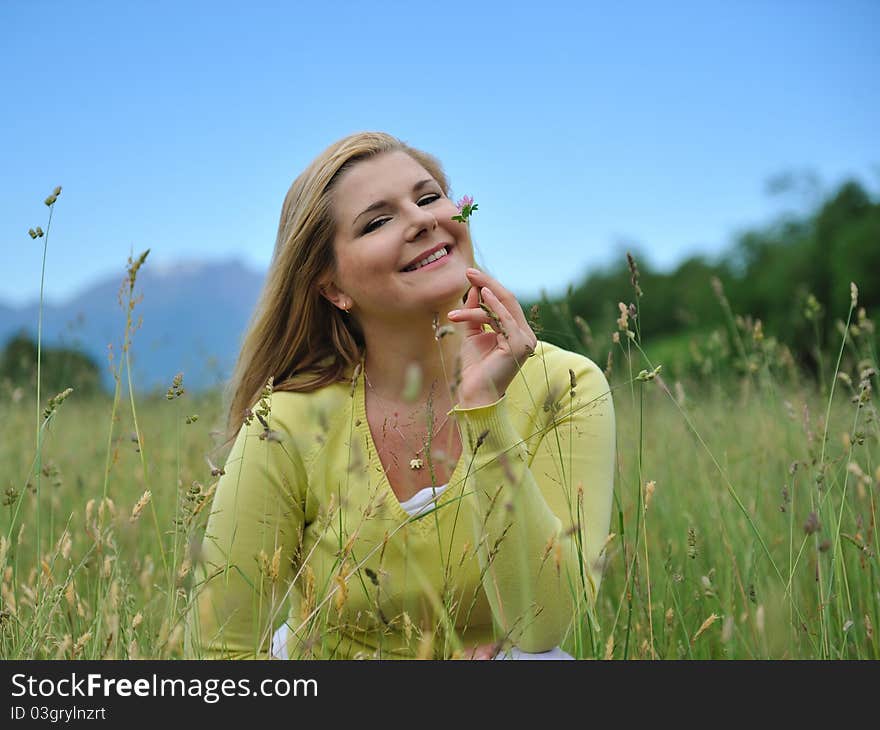 Pretty healthy summer woman outdoors on green field in Alps enjoying freedom. Switzerland. Pretty healthy summer woman outdoors on green field in Alps enjoying freedom. Switzerland