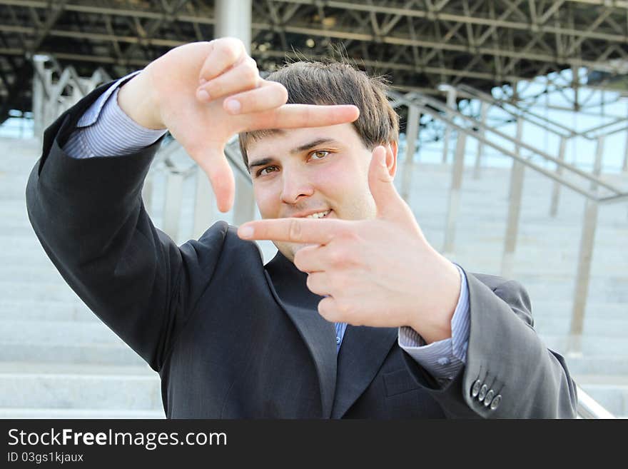 Hand composing. Young businessman holds his hands in the face in the form of a frame. Hand composing. Young businessman holds his hands in the face in the form of a frame