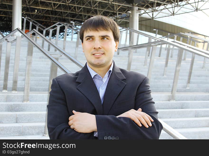 Closeup of a young businessman outdoors arms crossed on his chest