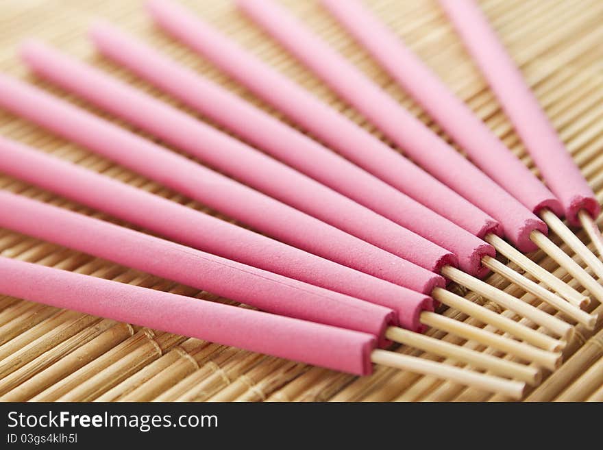 Spa treatment in bright pink palette, and arotatizirovannye sticks on a wooden bamboo rug