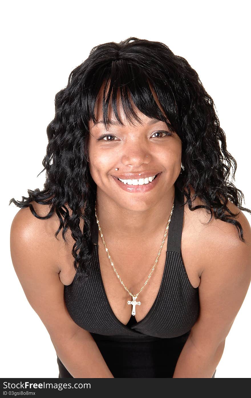 A pretty African-American woman in a black dress and black hair
standing in the studio bending forward, for white background. A pretty African-American woman in a black dress and black hair
standing in the studio bending forward, for white background.