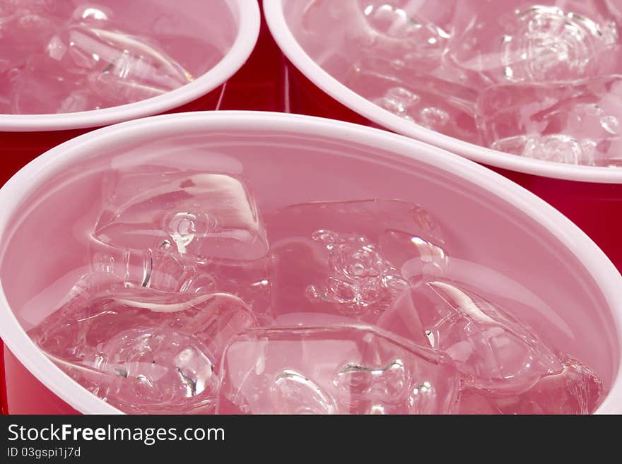 Water and ice in a red disposable cup. Water and ice in a red disposable cup.