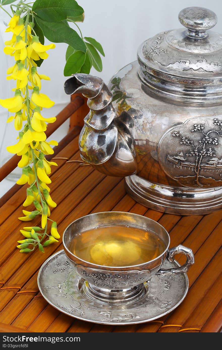 Green tea in a cup, flowers, yellow acacia on a bamboo tray. Green tea in a cup, flowers, yellow acacia on a bamboo tray