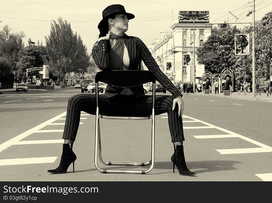 Woman In A Suit Sitting On A Chair On A Highway