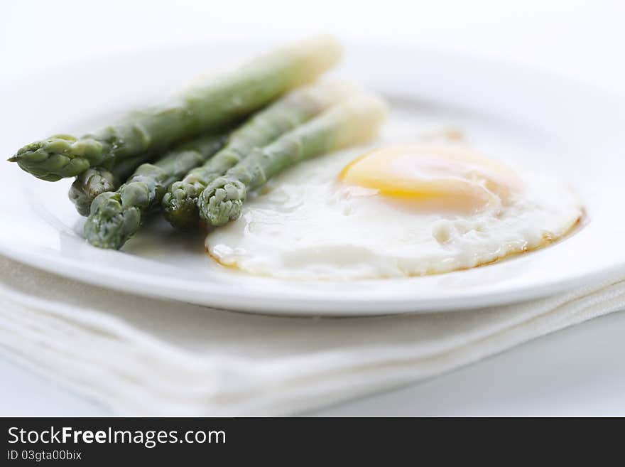 Asparagus with eggs on white plate