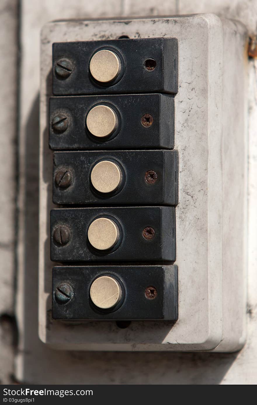 Row of old doorbells on an abandoned building