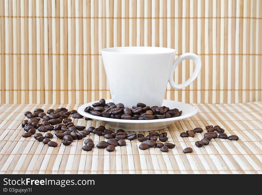 White cup and saucer with coffee beans. White cup and saucer with coffee beans