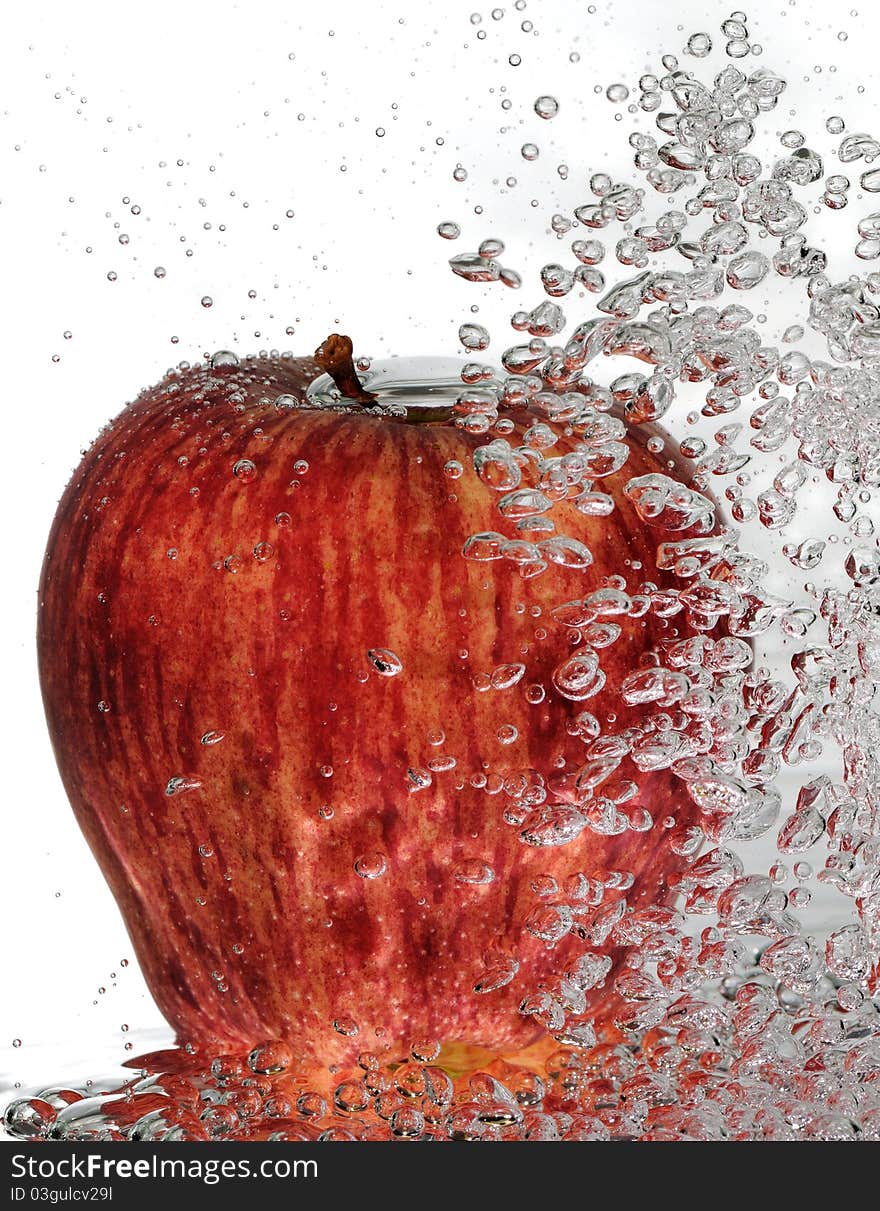 A ripe, red delicious apple with rising water bubbles. A ripe, red delicious apple with rising water bubbles.