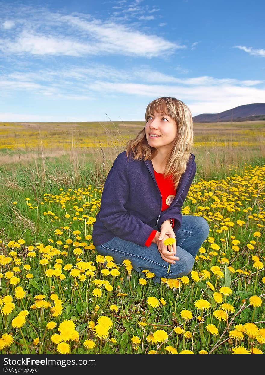 Beautiful girl on a dandelions field