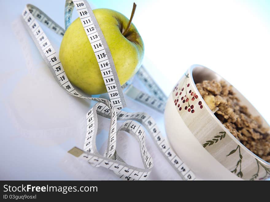 Bolw of corn flakes with green apple and measuring tape. Bolw of corn flakes with green apple and measuring tape