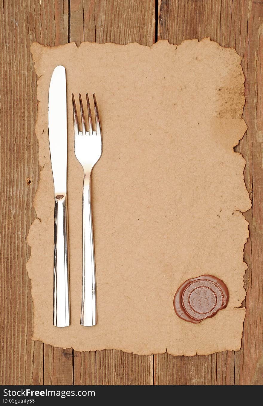 Knife and fork on old paper. space for the text