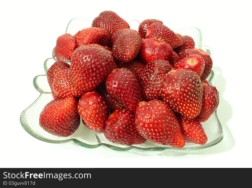 A glass plate with strawberries on a white background. A glass plate with strawberries on a white background