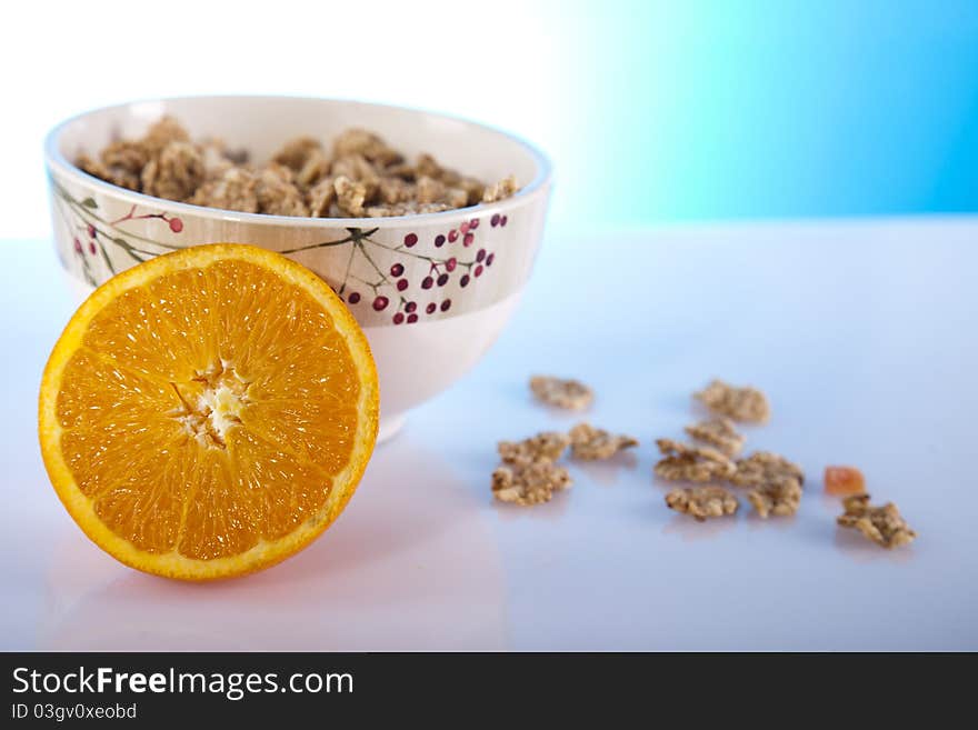 Cornflakes in a bowl and orange. Cornflakes in a bowl and orange