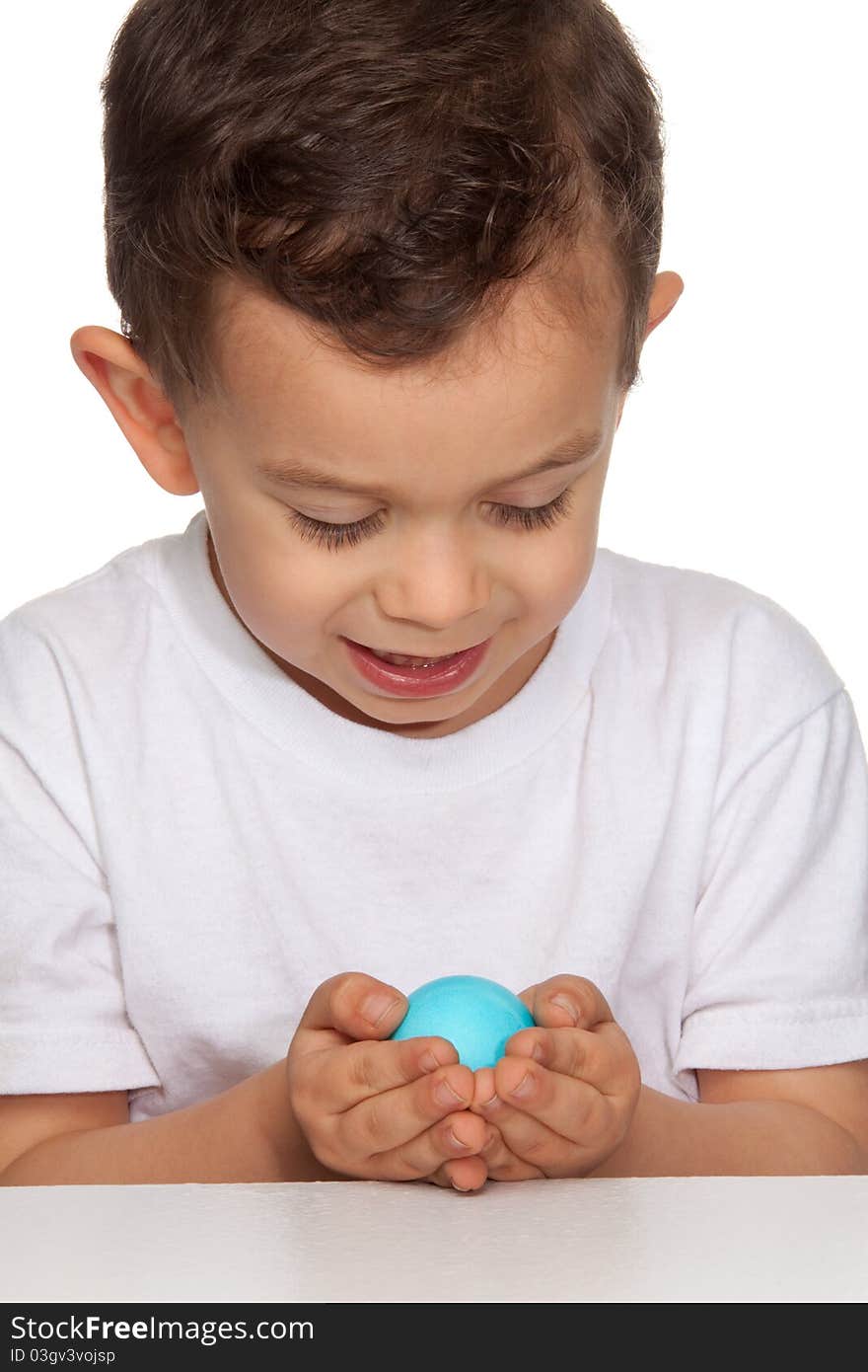 Young boy holding blue egg, white background. Young boy holding blue egg, white background