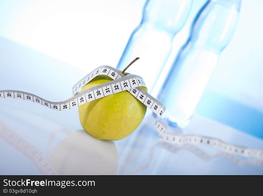 Mineral water with green apple and measuring tape. Mineral water with green apple and measuring tape