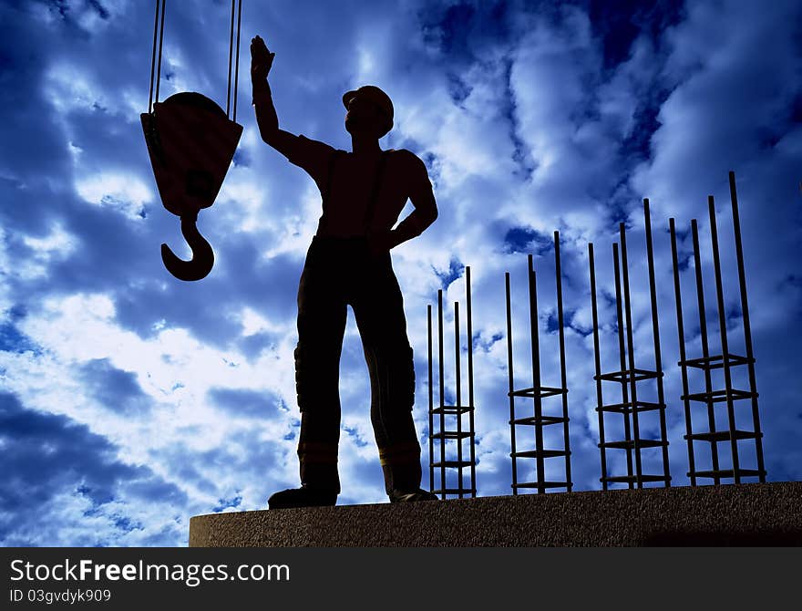 Silhouette of a worker on a background sky