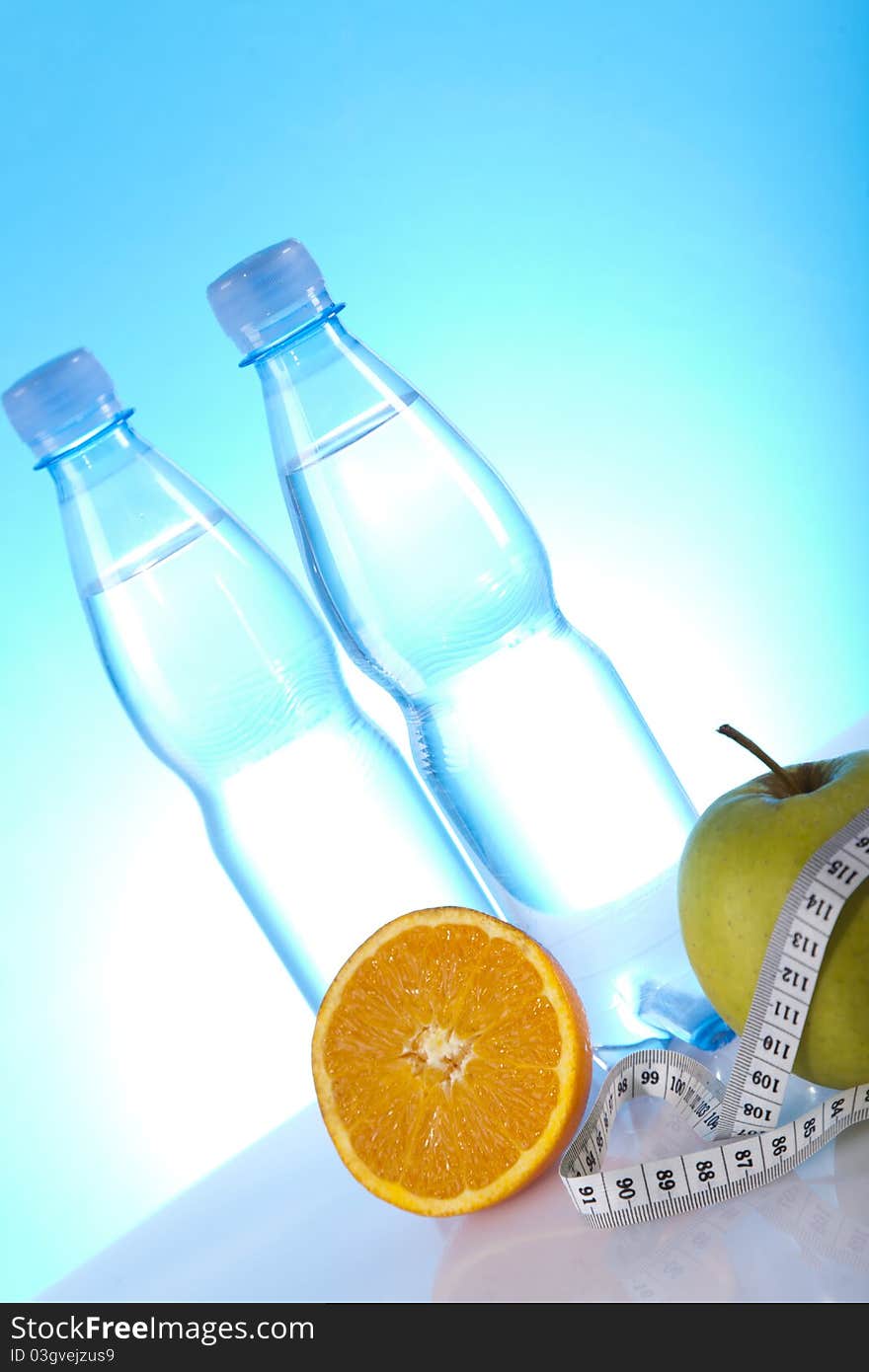 Bottles of mineral water with fruits and measuring tape. Bottles of mineral water with fruits and measuring tape