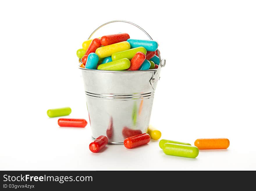 Lots of colorful flowers in a steel bucket. Isolated on white background. Lots of colorful flowers in a steel bucket. Isolated on white background