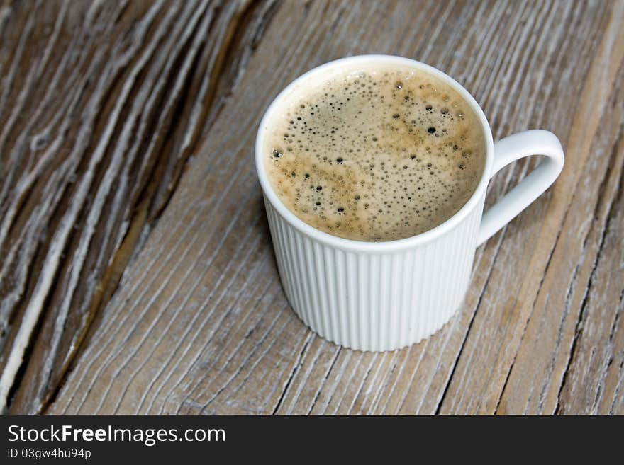 White cup of coffee on wooden table