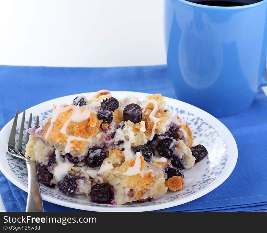 Plate of blueberry bread pudding with cup of coffee