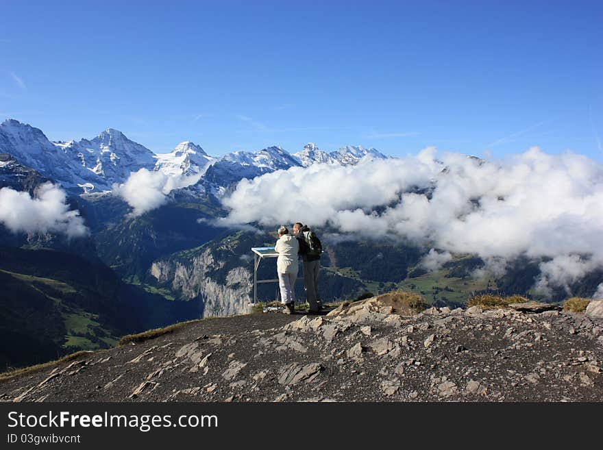 Two people viewing the mountain range in Switzerland. Two people viewing the mountain range in Switzerland