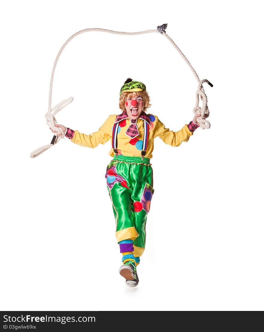 Cheerful clown jumps on a skipping rope isolated on a white background