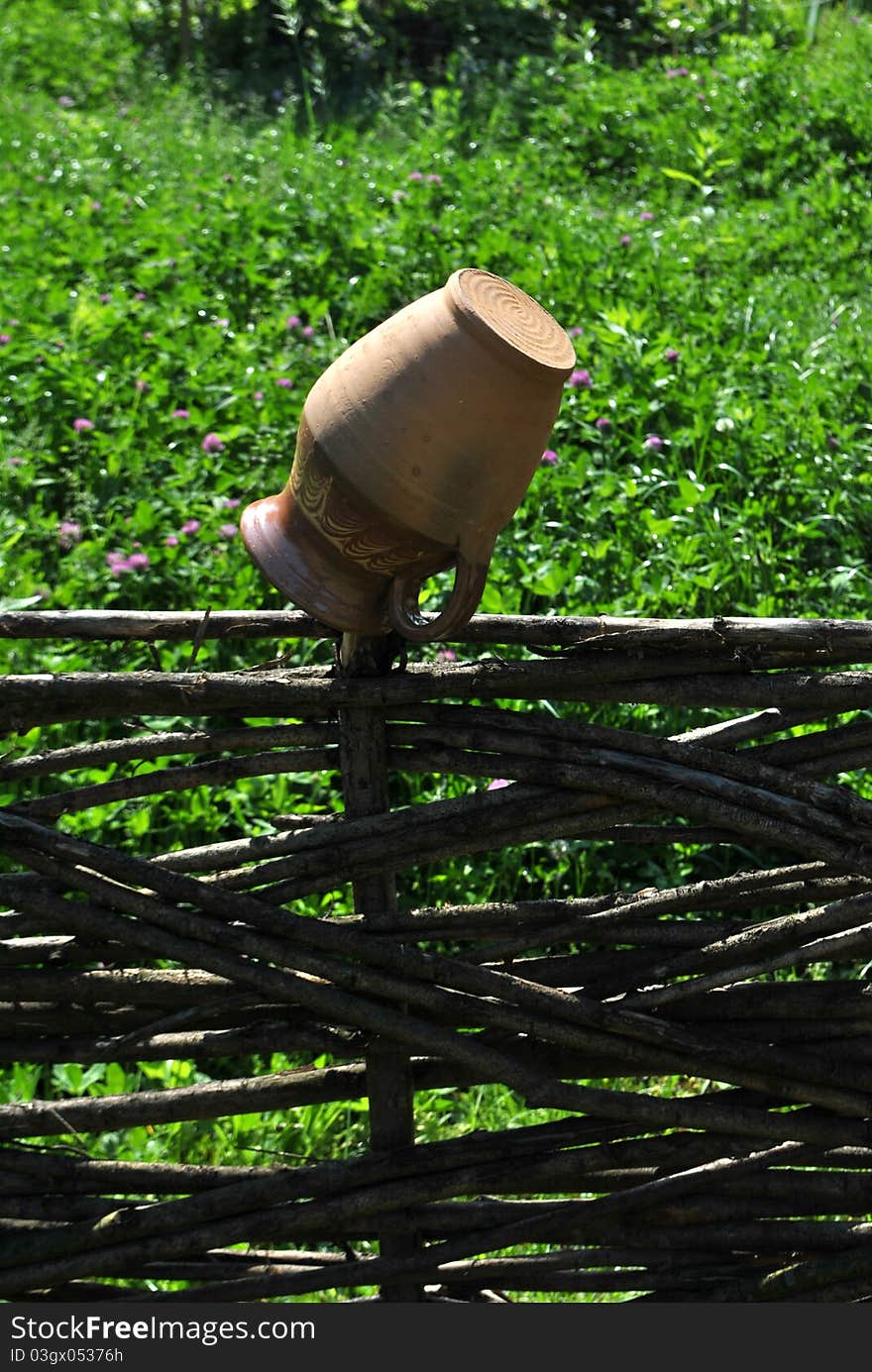 Image of a clay pitcher hanged on the fence