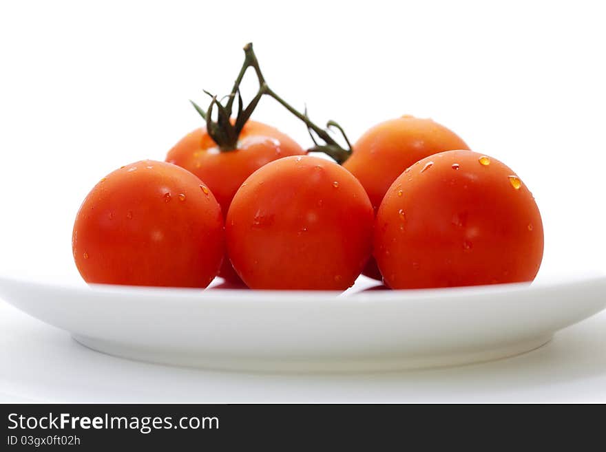 Macro of five tomatoes on a plate.